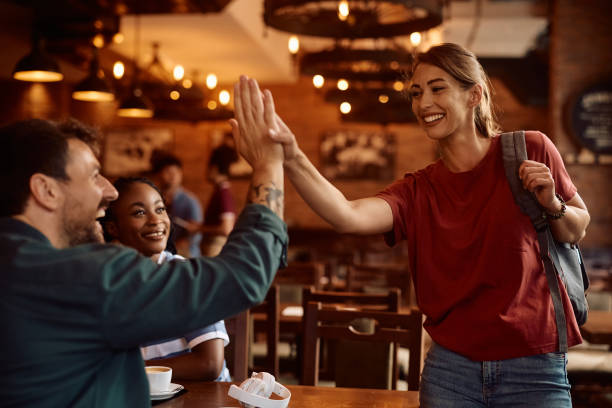 istock Happy friends greeting while gathering in a cafe. 2164278811