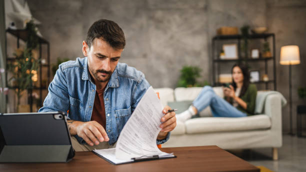 istock Adult man work from home read document, insurance on clipboard 2164280153