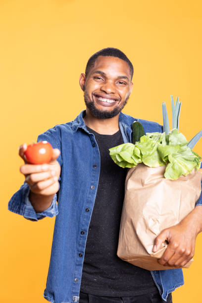 istock Vegan african american guy showing ethically sourced fresh tomato on camera 2164281517
