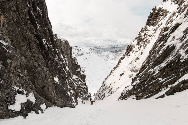istock Two skiers with their skis on their backs are climbing between rocky cliffs 2164284107