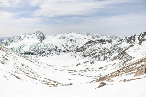 High angle view of a snow-covered mountain massif against a cloudless blue sky. Beautiful spring mountain landscape
