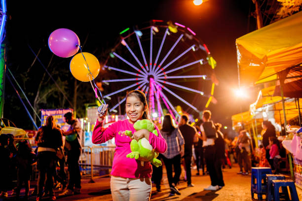 Young people visiting amusement park at night.