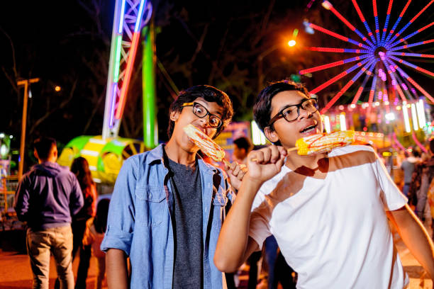 istock Young people visiting amusement park at night. 2164286965