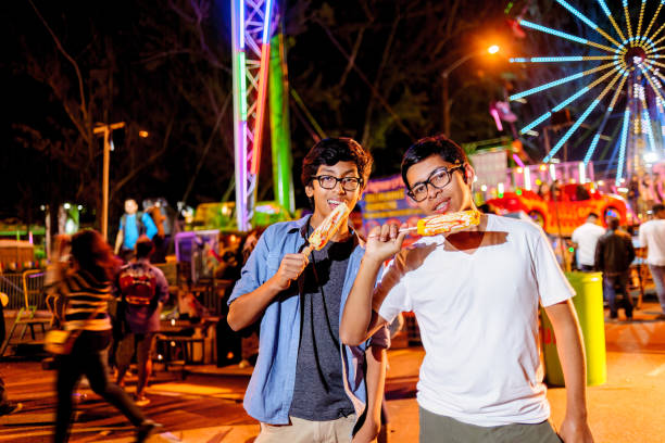 istock Young people visiting amusement park at night. 2164287030