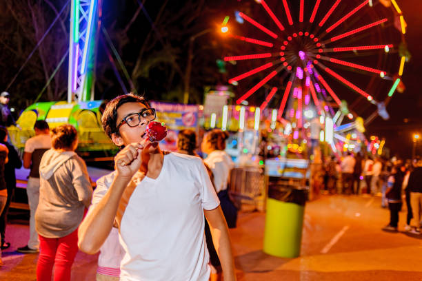 istock Young people visiting amusement park at night. 2164287065