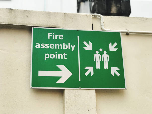 istock Emergency exit sign on the wall of a building. Keep your distance. 2164291294