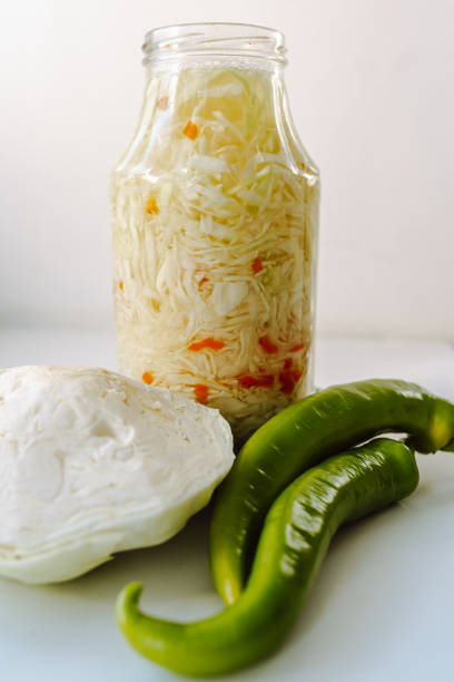 homemade fermented cabbage with spices, hot chili pepper, in a glass jar, fermentation process, salted sour cabbage, snack