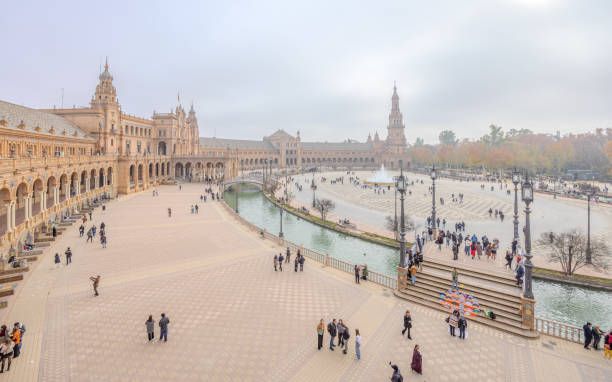 Seville, Spain - December 31, 2023:  Many visitors seen outside the majestic Plaza de Espana in a foggy afternoon on New Year Eve 2023.  HDR encoded.