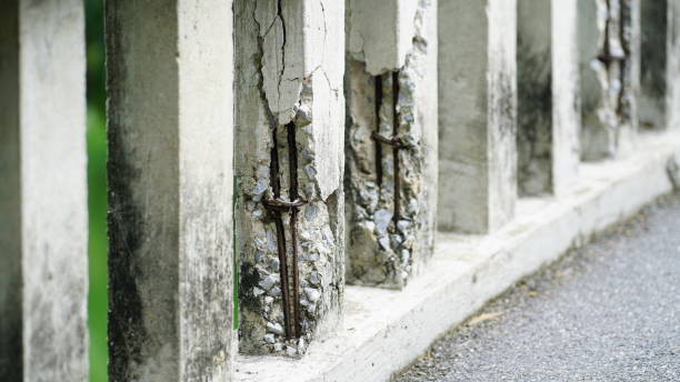 Damaged old reinforced concrete pillars, Cracked concrete surface with visible rusty reinforcement of bridge