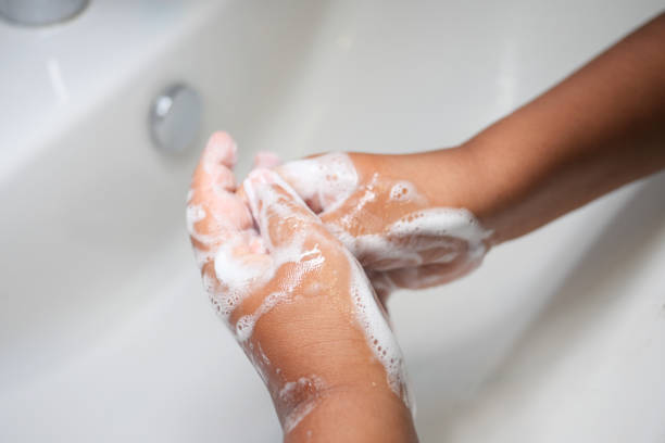 istock child making a cleansing gesture with soap and water on hands 2164299731