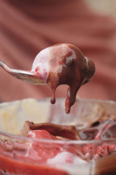 women hand with spoon eating ice cream on cafe table .