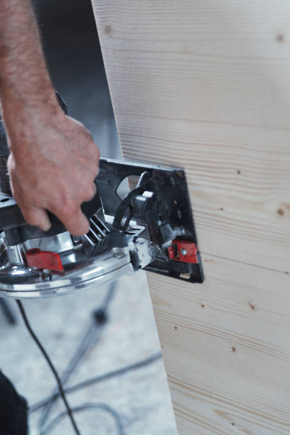 istock Carpenter using circular saw cutting wood plank in workshop 2164299897