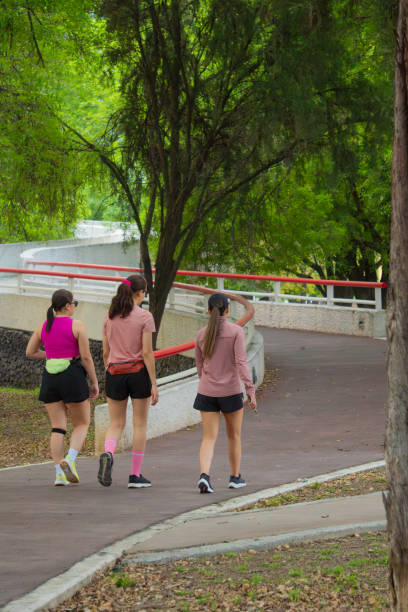 istock Latin Women Walking on Curved Path in Green Park 2164300916