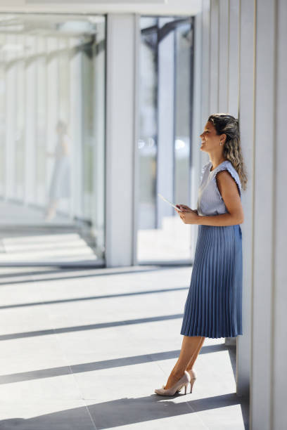 istock Happy female entrepreneur using touchpad in a hallway. 2164304267