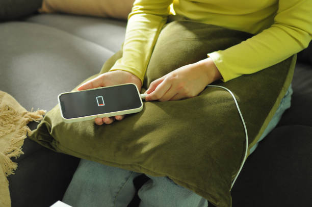 istock Woman hands Charging mobile phone battery with low battery. plugging a charger in a smart phone with energy bank powerbank power charger Modern lifestyle energy technology concept 2164304321