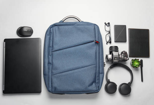 istock Backpack with photographer equipment and gadgets for work on white background. Flat lay. Top view 2164304811