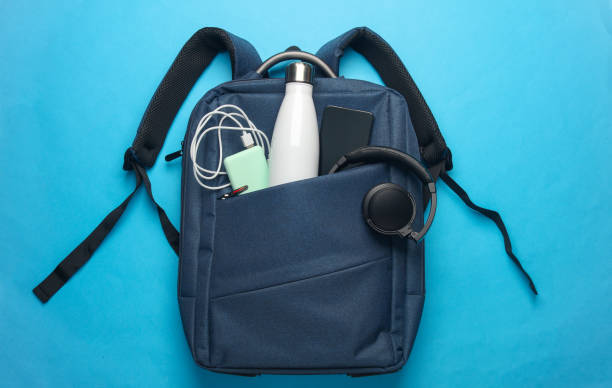 istock Modern gadgets and accessories for work and study in Backpack on pink background. Top view. Flat lay 2164304966
