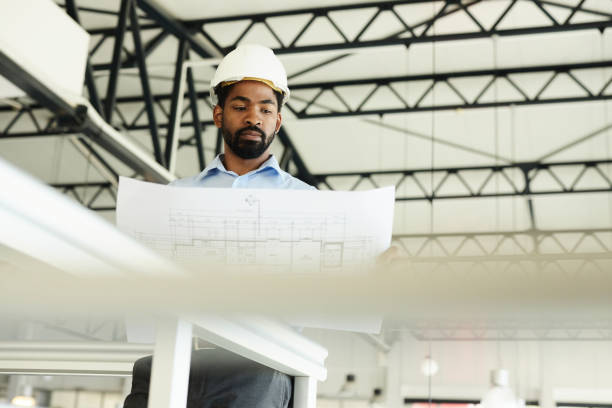 istock Below view of black architect analyzing blueprints in the building. 2164305059