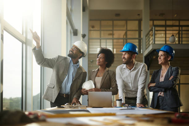 istock Team of happy architects making plans at construction site. 2164305185