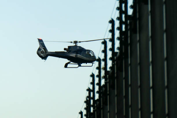 A sleek black helicopter soars through a clear blue sky, showcasing modern aviation and scenic flight experiences.