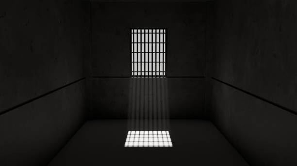 istock Small, dark prison cell with a barred window. Light from the window shines through the bars, casting a shadow on the floor. 3d render 2164306897