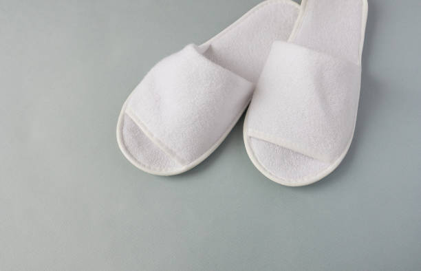 White hotel slippers on grey floor