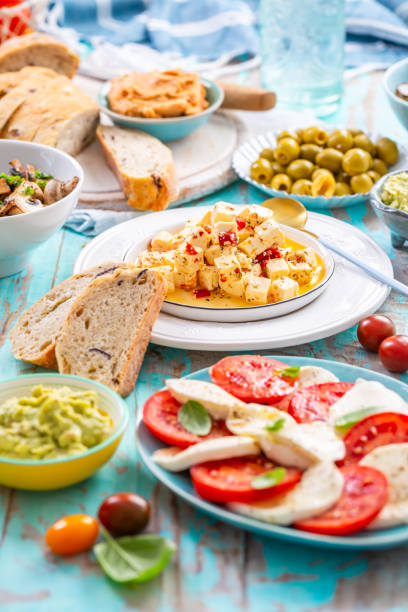 istock Picnic table with assorted appetizers, raw vegetables, cheese, dips, baguette and pastrami and serrano platter 2164311232