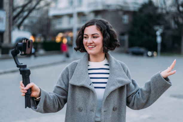 istock Young female content creator using smartphone to record outdoors. 2164312379