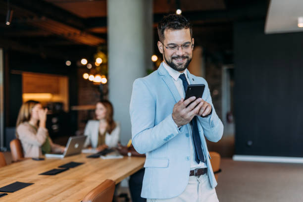 istock Businessman texting on his phone in the office. 2164312874