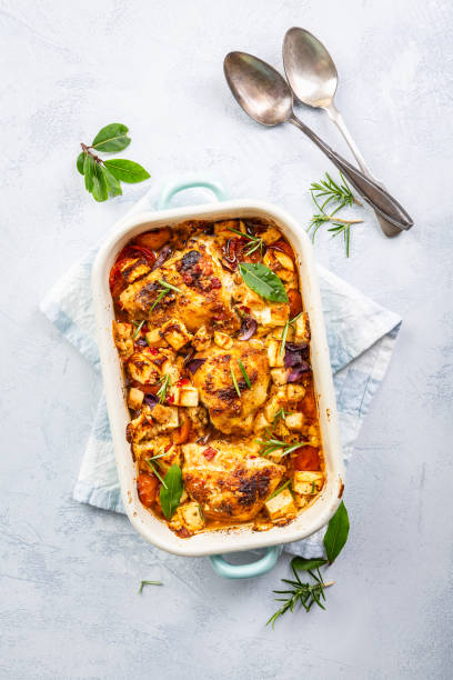 Baked chicken pieces with vegetable, tomato and feta cheese, casserole dish