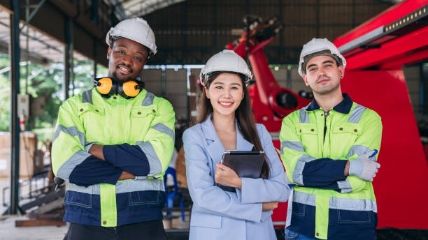 istock Three people wearing safety gear and holding tablets. Worker industry join hand for collaboration. 2164315055