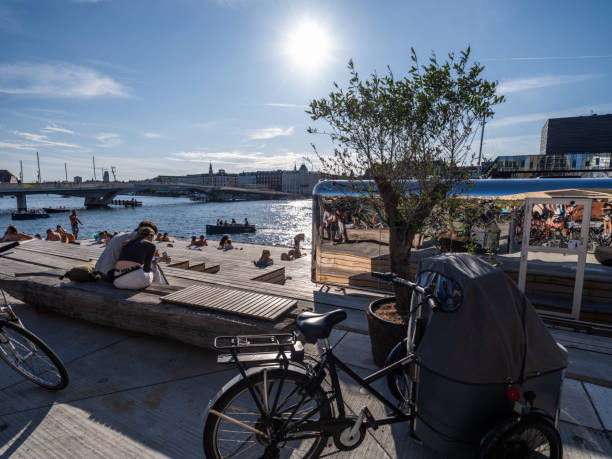 Copenhagen, Denmark - July 29, 2024: Young people enjoying the low, summer afternoon sun in Copenhagen Inner Harbour.