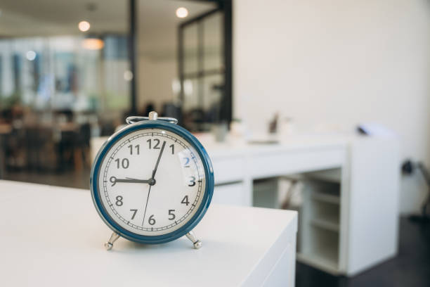 istock A blue alarm clock sits on a white desk in a room 2164319168
