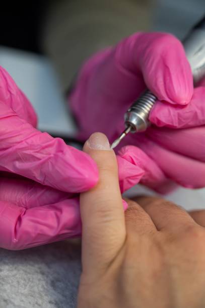 istock The master makes a hardware manicure to a male client. 2164319373
