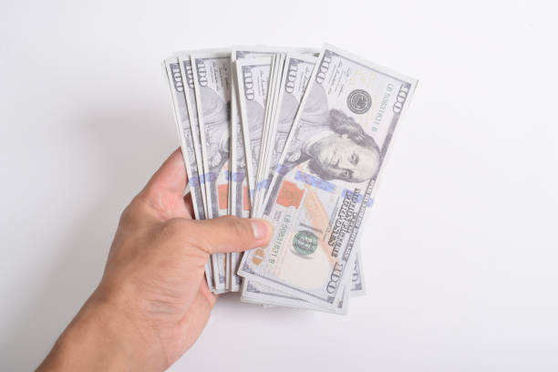 istock Man hand reaching out dollar bill. US $100 banknote 2164322108