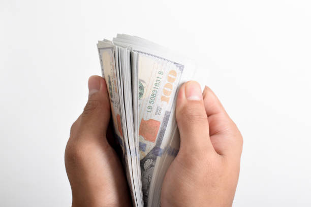 istock Close-up Hands counting money American dollars, 100 USD 2164322542