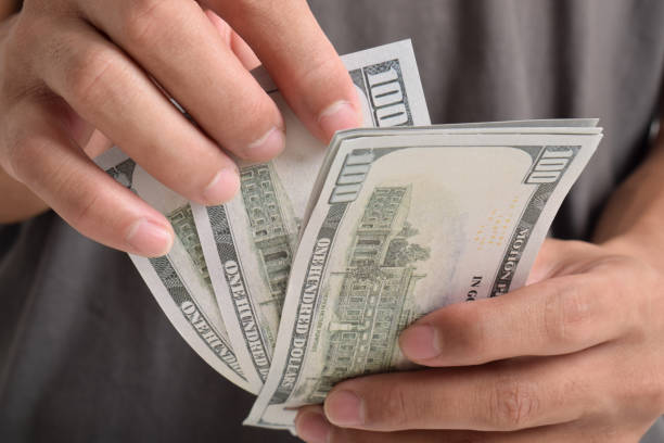 istock Close-up Hands counting money American dollars 2164323103