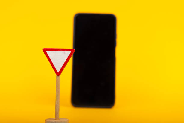 istock Yield Sign and Smartphone on Yellow Background 2164323953