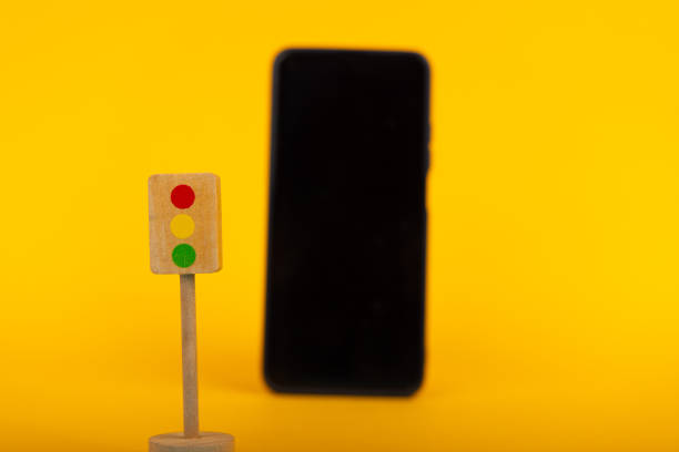 istock Toy Traffic Light with Blurred Smartphone 2164323962