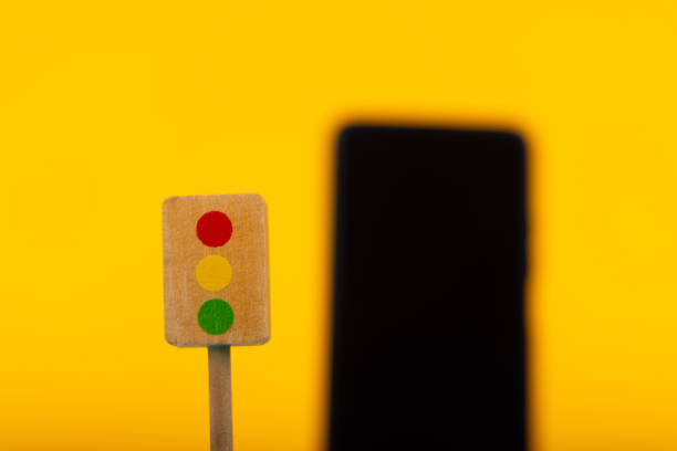 istock Wooden Traffic Light with Blurred Smartphone 2164324012