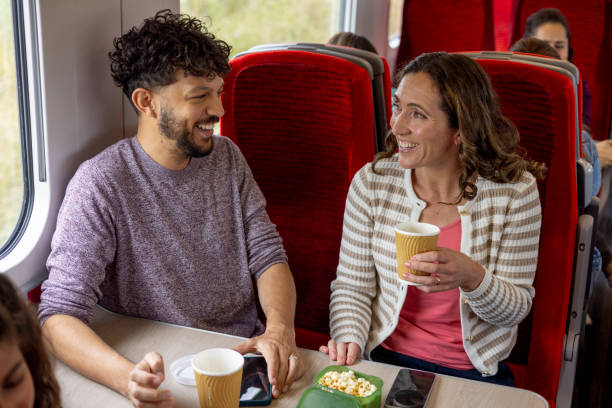 istock Couple Smiling and Chatting on the Train 2164325495