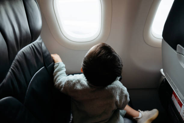 istock Asian little boy looking out airplane window 2164326123