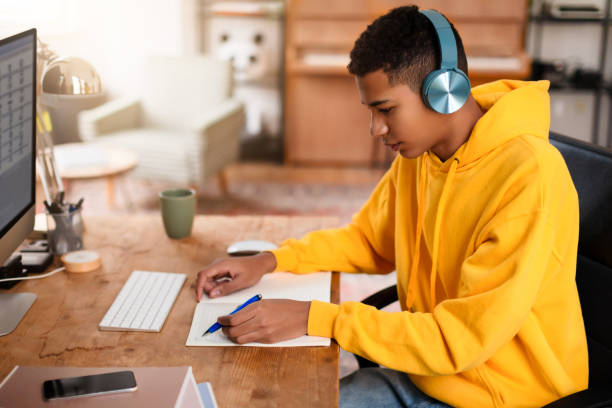istock Individual writing in notebook at desk 2164328144