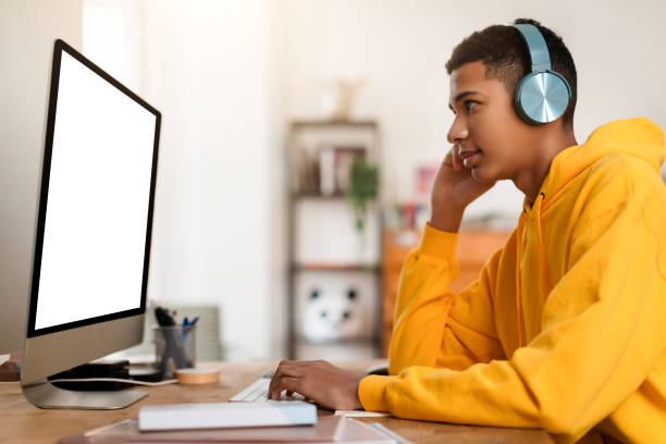 istock Man in yellow hoodie working at computer 2164328154