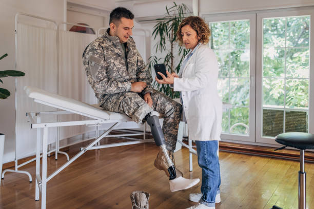 istock Doctor consulting soldier with leg prosthetic on table. 2164328646