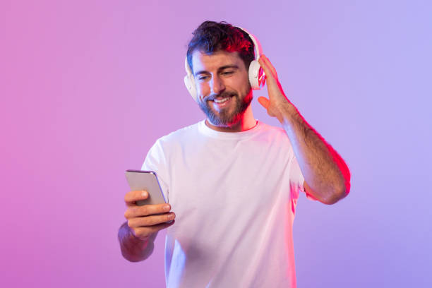 istock Man Listening to Music While Holding a Cell Phone 2164329002