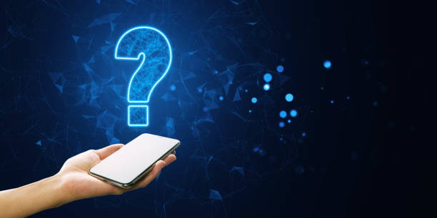 istock Hand holding smartphone with glowing question mark over dark background. 2164330707