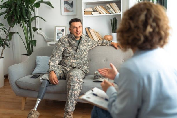 istock Soldier with a prosthetic leg conversing with psychologist on therapy couch 2164330745