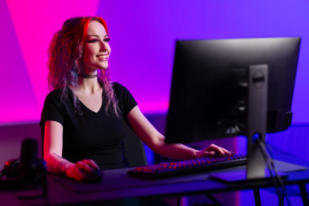 istock Professional gamer smiling while playing a PC game in a vibrant room with neon lighting 2164330796