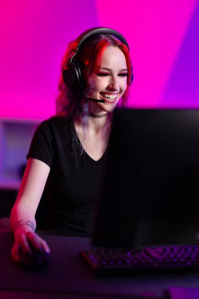 istock Professional gamer plays enthusiastically in a colorful room with headset and computer setup 2164330840
